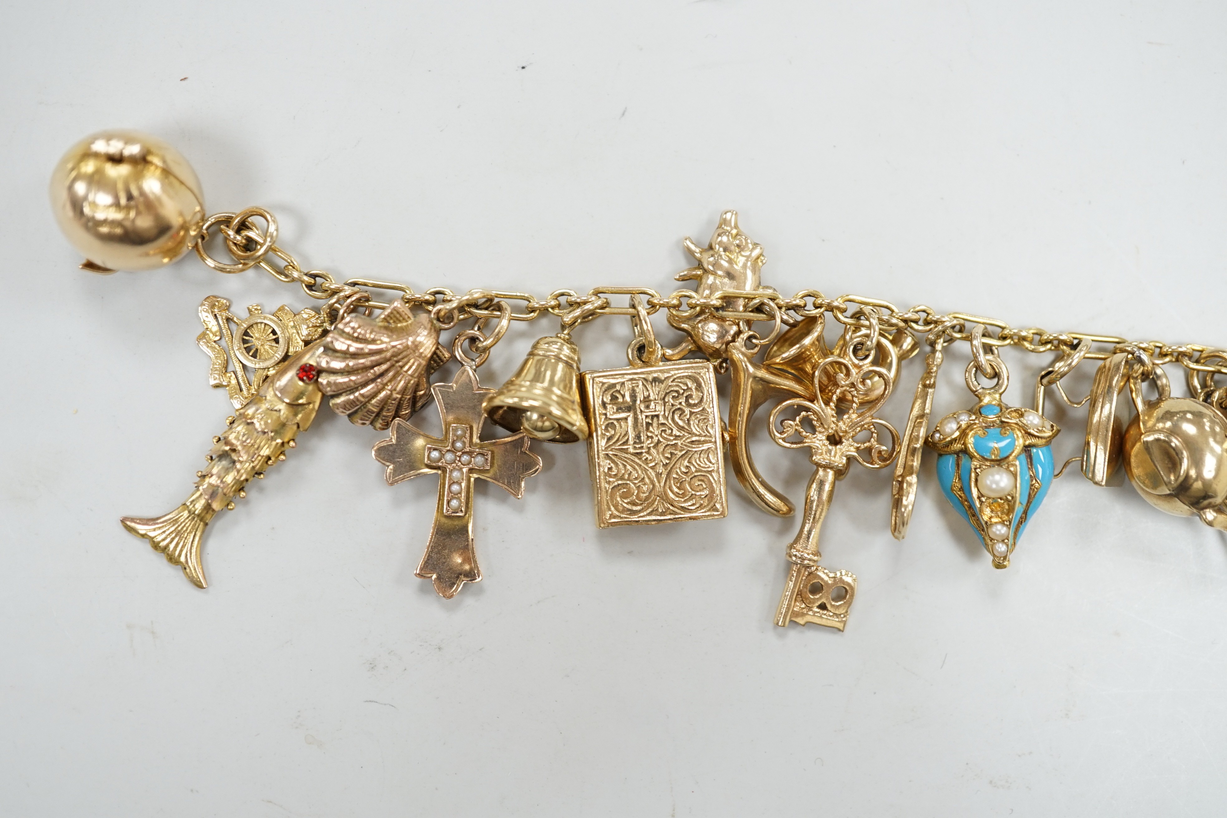 A 9ct charm bracelet, hung with assorted mainly 9ct gold charms, gross weight 46.1 grams.